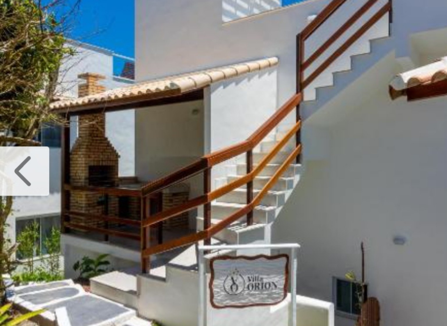 Área externa com escadas e detalhes em madeira da Villa Orion